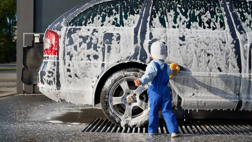 An 85AutoSpa technician detailing a car in a Sandy Springs driveway, showcasing the convenience of mobile service.