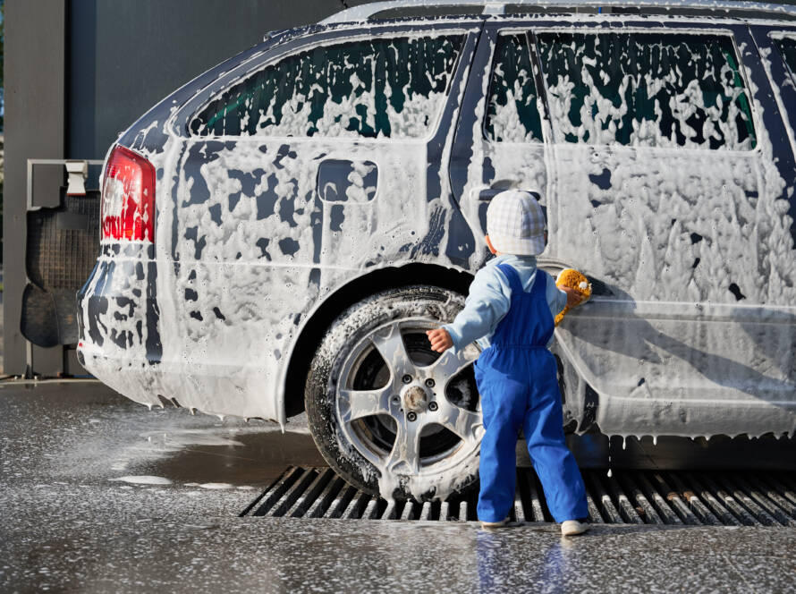 An 85AutoSpa technician detailing a car in a Sandy Springs driveway, showcasing the convenience of mobile service.