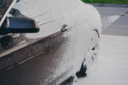 A sleek, black car parked in front of a Sandy Springs landmark, showcasing its stunning appearance after detailing.