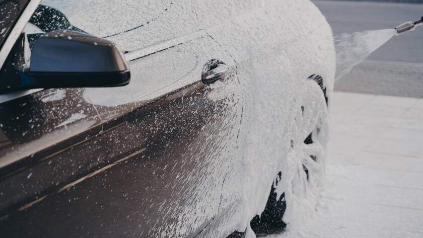 A sleek, black car parked in front of a Sandy Springs landmark, showcasing its stunning appearance after detailing.