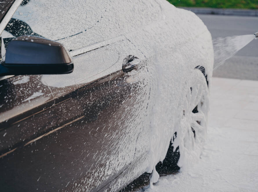 A sleek, black car parked in front of a Sandy Springs landmark, showcasing its stunning appearance after detailing.