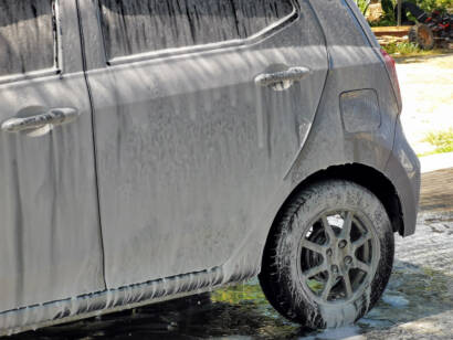 A clear, transparent film being applied to a car's front bumper.