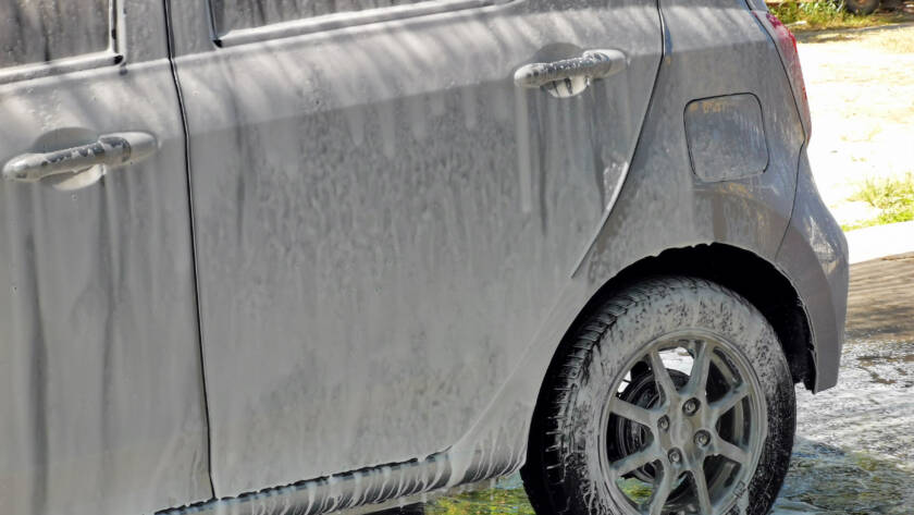 A clear, transparent film being applied to a car's front bumper.