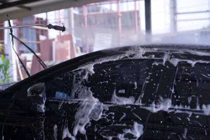 A before-and-after photo of a car door with swirl marks removed after paint correction.