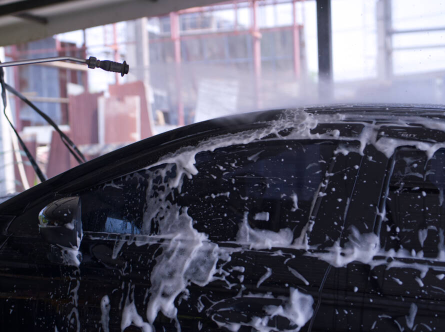 A before-and-after photo of a car door with swirl marks removed after paint correction.