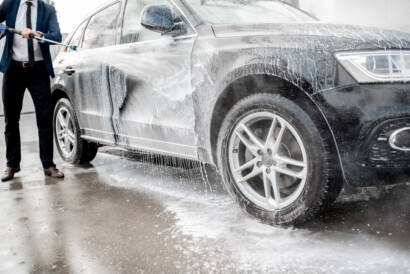 A close-up photo of a soft microfiber mitt being used to wash a car at 85AutoSpa.