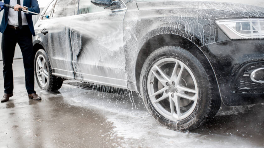 A close-up photo of a soft microfiber mitt being used to wash a car at 85AutoSpa.