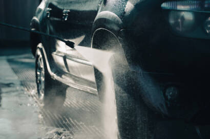 A close-up photo of a water droplet beading on a ceramic-coated car surface, showcasing its hydrophobic properties.