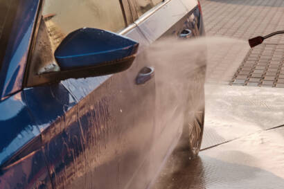 85AutoSpa's mobile detailing van parked in front of a house, with a technician washing a car.