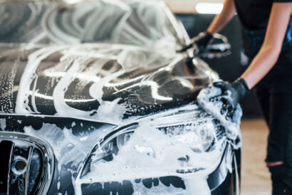 A before-and-after photo of a car's engine bay, showing the dramatic difference after professional cleaning.