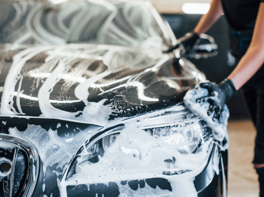 A before-and-after photo of a car's engine bay, showing the dramatic difference after professional cleaning.