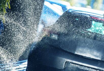 A clear, transparent film being applied to a car's front bumper.