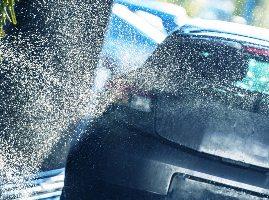 A clear, transparent film being applied to a car's front bumper.