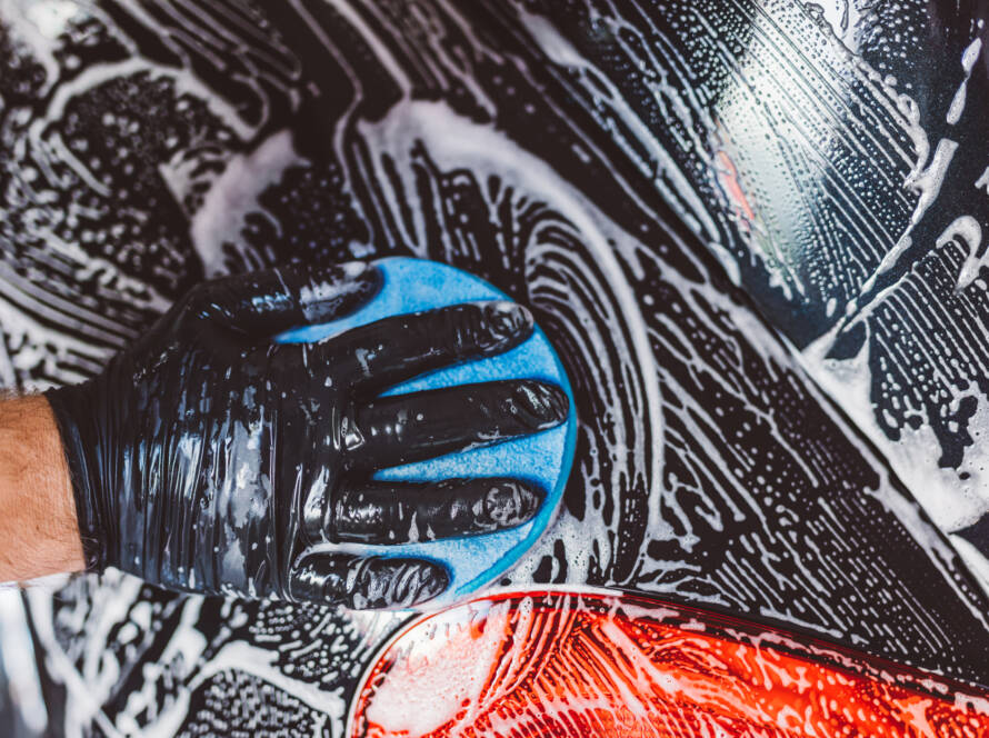 A close-up photo of a water beading on a ceramic-coated car panel, showcasing its hydrophobic properties.