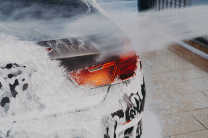 A close-up image of water beading on a ceramic-coated car hood, showcasing its hydrophobic properties.