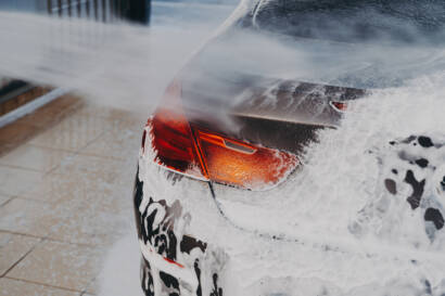 A close-up of a car's front bumper with transparent PPF applied, demonstrating its invisible protection.